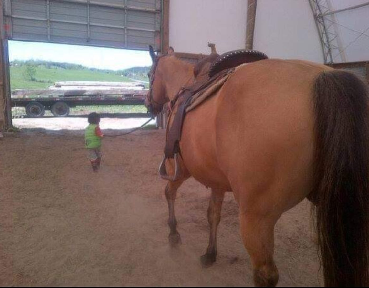 Sierra walking out of the barn beside a small child